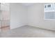 Bright bedroom featuring neutral carpeting and a large window with bathroom access at 1039 Wisteria Way, Dundee, FL 33838