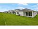 A long row of houses in a green yard with an air conditioning unit near the patio at 1039 Wisteria Way, Dundee, FL 33838