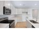 Well-equipped kitchen featuring white cabinetry, quartz countertops, and stainless steel appliances at 1039 Wisteria Way, Dundee, FL 33838