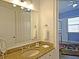 Bright bathroom featuring a granite vanity top, large mirror, and neutral walls at 1057 Castle Pines Ct, Reunion, FL 34747
