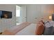 Bright bedroom features a dresser with TV, closet and two doors at 1057 Castle Pines Ct, Reunion, FL 34747