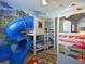 Fun bedroom with bunk beds, a slide, and themed wallpaper for imaginative play at 1057 Castle Pines Ct, Reunion, FL 34747