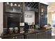 Stylish coffee bar featuring black cabinetry, granite countertops, and built-in wine storage at 1057 Castle Pines Ct, Reunion, FL 34747