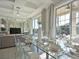 Dining table set with glass top, visible TV, and large glass doors allowing an abundance of light at 1057 Castle Pines Ct, Reunion, FL 34747