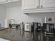 Kitchenette features modern appliances, granite countertops and white cabinetry at 1057 Castle Pines Ct, Reunion, FL 34747