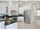 Gourmet kitchen boasting stainless steel appliances, granite countertops and custom white cabinetry at 1057 Castle Pines Ct, Reunion, FL 34747