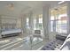 Luxury main bedroom features a four-poster bed, sitting area, and a view of the outdoor area at 1057 Castle Pines Ct, Reunion, FL 34747
