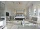 Luxury main bedroom featuring a four-poster bed, sitting area, and access to a private balcony at 1057 Castle Pines Ct, Reunion, FL 34747