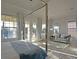 Bright main bedroom features a four-poster bed, sitting area, and access to a balcony at 1057 Castle Pines Ct, Reunion, FL 34747