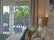 Bright main bedroom with sliding glass door view of patio, garden and chess set at 1057 Castle Pines Ct, Reunion, FL 34747