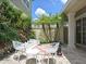 Outdoor chess area with tropical landscaping and modern patio furniture at 1057 Castle Pines Ct, Reunion, FL 34747