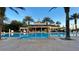 Large community pool with palm trees and clubhouse creates a resort-style living experience at 1057 Castle Pines Ct, Reunion, FL 34747