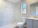 Bathroom features white marbled tile, a gray vanity and a window at 1085 Whitewood Dr, Deltona, FL 32725