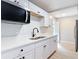 Modern kitchen featuring white cabinets, stainless steel appliances, and a stylish black faucet, ready for cooking and entertaining at 1085 Whitewood Dr, Deltona, FL 32725