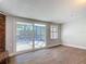Cozy living area with sliding glass doors, brick fireplace, and tile floors providing seamless indoor-outdoor living at 1085 Whitewood Dr, Deltona, FL 32725