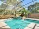Sparkling screened-in pool features a lovely water feature, surrounded by lush landscaping at 1085 Whitewood Dr, Deltona, FL 32725