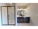 Modern bathroom features a double sink vanity, decorative lights and a frameless glass shower with unique herringbone tiling at 1110 Olivine Ave, Dundee, FL 33838