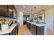 Modern kitchen featuring stainless steel appliances, dark cabinetry, a white countertop island, and pendant lighting at 1110 Olivine Ave, Dundee, FL 33838