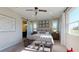 Serene main bedroom featuring a tufted headboard, sliding barn door to en suite, and plenty of natural light at 1110 Olivine Ave, Dundee, FL 33838