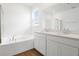 Bathroom features double vanity, white cabinets, soaking tub and wood-look flooring at 1114 Olivine Ave, Dundee, FL 33838