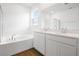 Bathroom features double vanity, white cabinets, soaking tub and wood-look flooring at 1114 Olivine Ave, Dundee, FL 33838
