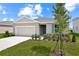 Charming single-story home with a two-car garage, landscaped yard, and lovely blue shutter at 1114 Olivine Ave, Dundee, FL 33838