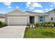 Charming single-story home with a two-car garage, landscaped yard, and lovely blue shutter at 1114 Olivine Ave, Dundee, FL 33838