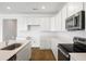 Modern kitchen with white cabinetry, stainless steel appliances, and quartz countertops at 1114 Olivine Ave, Dundee, FL 33838