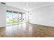 Bright, open living room with sliding glass doors to the outside and wood-look flooring at 1114 Olivine Ave, Dundee, FL 33838