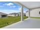 View from back porch looking out at green grass and houses on a partly cloudy day at 1118 Olivine Ave, Dundee, FL 33838