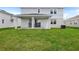 A view of the backyard featuring a covered patio and lush green lawn at 1118 Olivine Ave, Dundee, FL 33838