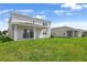 A spacious backyard featuring a covered patio and green grass at 1118 Olivine Ave, Dundee, FL 33838