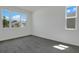 An empty bedroom with neutral walls and light tile flooring, featuring two windows that brighten the room at 1118 Olivine Ave, Dundee, FL 33838