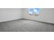 Carpeted bedroom with a double window offers natural light and exterior views at 1118 Olivine Ave, Dundee, FL 33838