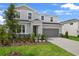 Two-story home with gray siding, stone accents, manicured lawn, and an attached two-car garage in a suburban neighborhood at 1118 Olivine Ave, Dundee, FL 33838