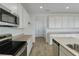 Bright kitchen featuring white cabinetry, stainless steel appliances, light countertops and wood-look tile flooring at 1118 Olivine Ave, Dundee, FL 33838