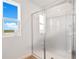 Bathroom features a glass-enclosed shower and a window with exterior view at 1118 Olivine Ave, Dundee, FL 33838