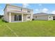 Spacious backyard with a covered patio, great for outdoor gatherings and enjoying the fresh air at 1130 Olivine Ave, Dundee, FL 33838