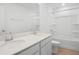 Bright bathroom featuring dual sinks, white cabinets, and a shower and tub at 1130 Olivine Ave, Dundee, FL 33838