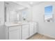 Bright bathroom featuring dual sinks, white cabinets, and a walk in shower at 1130 Olivine Ave, Dundee, FL 33838