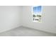 Sunny bedroom featuring neutral carpet, light walls, and a window view to outside at 1130 Olivine Ave, Dundee, FL 33838