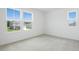 Sunny bedroom with neutral carpet and a window view of neighboring houses at 1130 Olivine Ave, Dundee, FL 33838