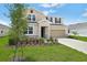 Charming two-story home featuring a manicured lawn, stone accents, and a neutral color palette at 1130 Olivine Ave, Dundee, FL 33838