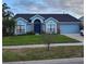 Inviting one-story home with lush green lawn, blue exterior, and attached garage at 12966 Broakfield Cir, Orlando, FL 32837