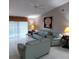 Living room with tile floors, ceiling fan, couches, sliding glass doors, and a decorative painting at 12966 Broakfield Cir, Orlando, FL 32837
