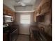 Galley style kitchen with granite countertops, stainless steel oven, and wood cabinets at 1304 Mill Creek Pl, Kissimmee, FL 34744