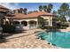Community pool area with several lounge chairs and an elegant covered building at 14049 Fairway Island Dr # 127, Orlando, FL 32837