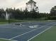 Outdoor community tennis court with a lush green background featuring a fountain at 14049 Fairway Island Dr # 127, Orlando, FL 32837