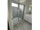 Bathroom featuring a walk-in shower with grey tile and a white sink vanity at 2414 Skyline Loop, Kissimmee, FL 34758