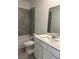 Bathroom with a shower/tub combo, white vanity, and grey accent tiles at 2414 Skyline Loop, Kissimmee, FL 34758